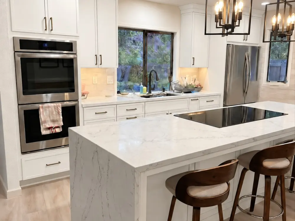 Slim shaker kitchen with white cabinetry, quartz island and warm wood accents